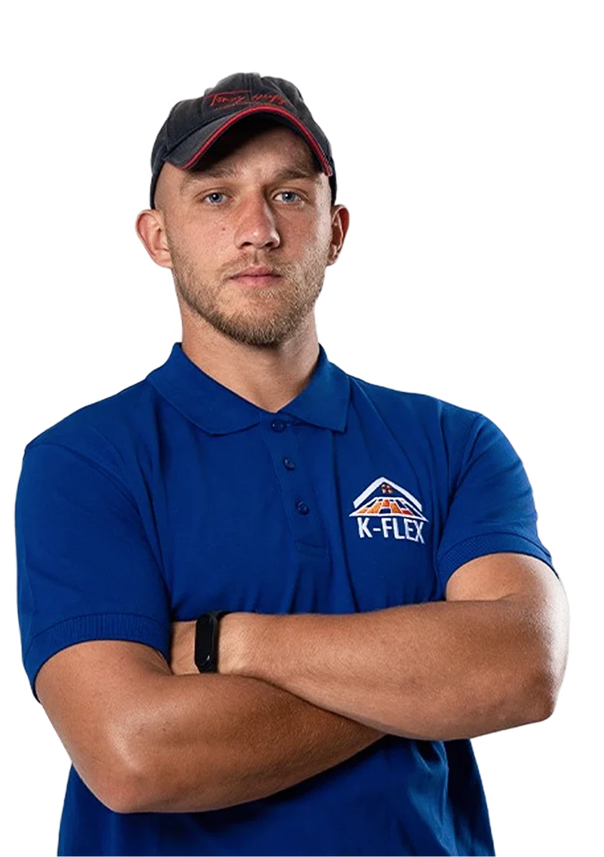 Junger Dachdecker im K-Flex-Poloshirt mit verschränkten Armen, bereit für Dachreparatur