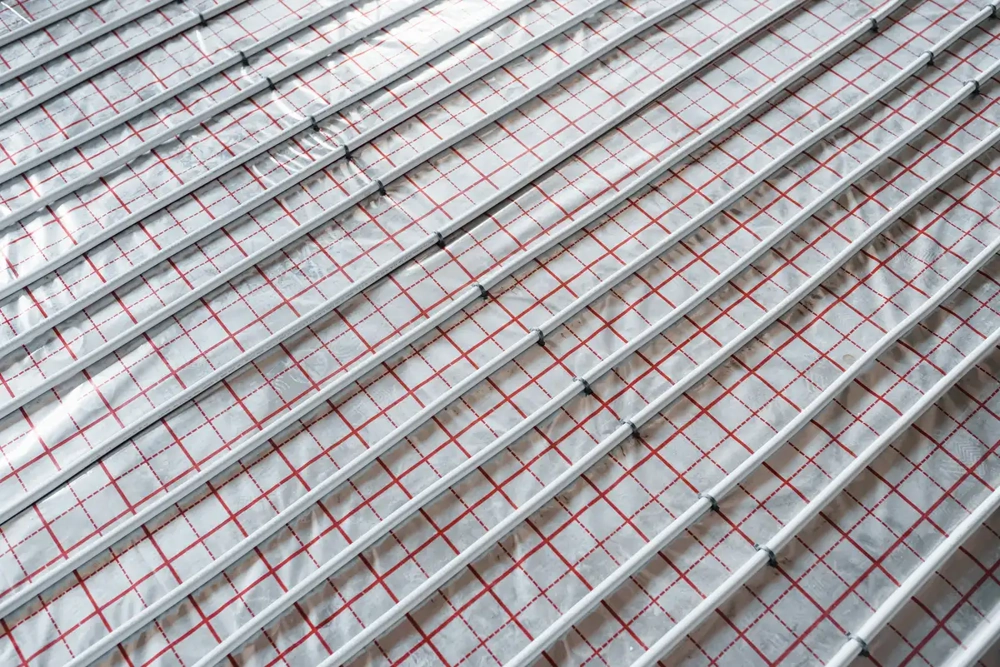 Verlegte Heizungsrohre auf Aluminiumfolie mit Rastermarkierung